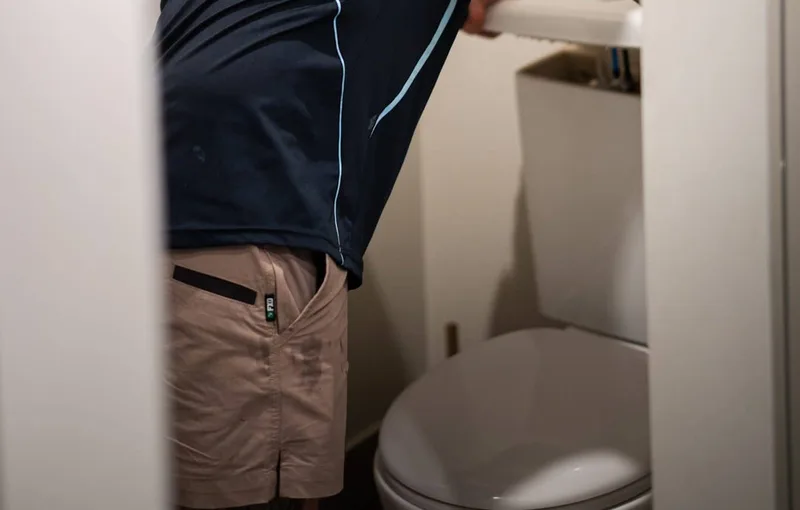 Plumber checking a toilet cistern