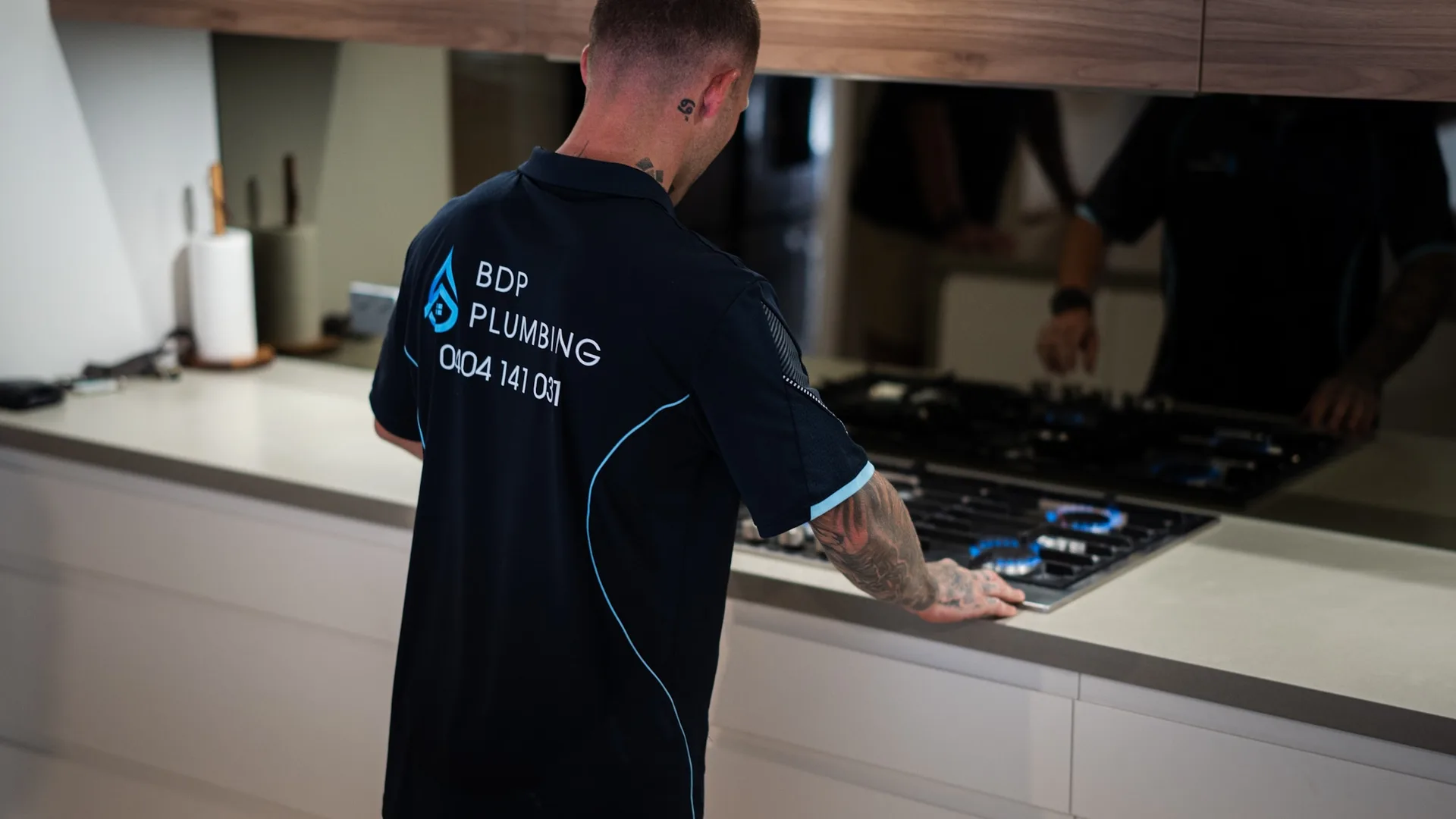 Plumber checking a gas cooktop connection