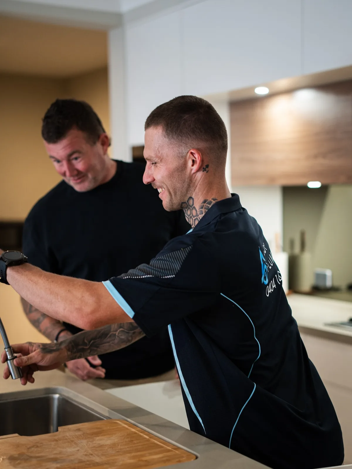 Plumber and homeowner at the kitchen sink